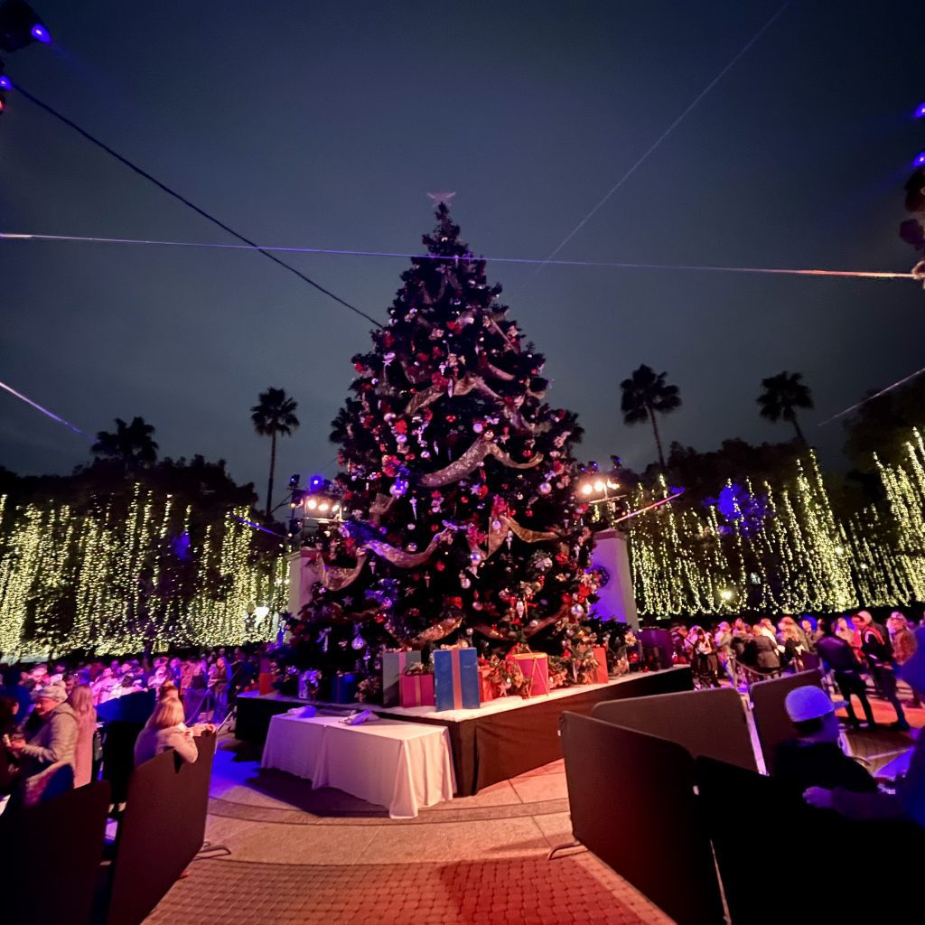 Crowd gathering around the unlit towering Christmas tree at the Paramount Studios lot in Hollywood, CA. Music for the event was created by EmotionCrafters.